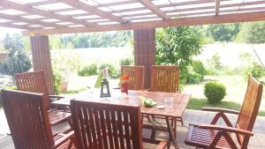 einen Holztisch und Stühle auf einer Terrasse in der Unterkunft Ferienhaus am Teich in Rottleberode