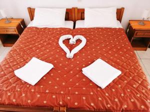Una cama con un corazón hecho de toallas en Star Apartment, en Kallithea Halkidikis 78 fotos más