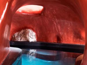 a ride in a water slide with a pool of water at Elysian Santorini in Oia