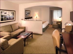 um quarto de hotel com um sofá e uma cama em Ann Arbor Regent Hotel and Suites em Ann Arbor