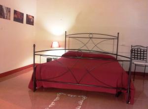 a bedroom with a metal bed with a red blanket at Suite Carducci B&B - Residence in Rutigliano