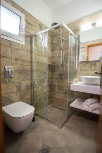 a bathroom with a shower and a toilet and a sink at Aloni Studios & Apartments in Athanion +81 photos