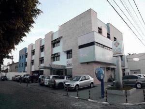 a parking lot with cars parked in front of a building at Portal da Princesa Hotel in Feira de Santana