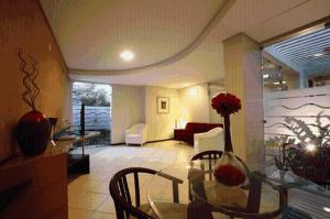 a living room with a glass table and chairs at Portal da Princesa Hotel in Feira de Santana
