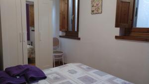 Un dormitorio con una cama con una toalla morada. en apartamento AZKOITI ETXEA, en Ochagavía