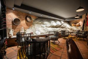 a bar with chairs and a stone wall at Hotel Adamo in Tbilisi City