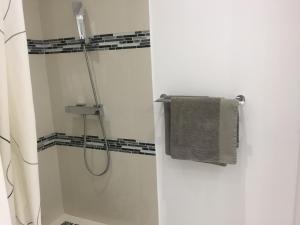 a white bathroom with a shower with a towel at Studio de Luxe TIARE Orient Bay Citerne in Orient Bay +11 photos