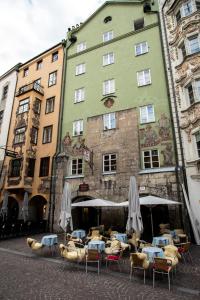 ein Gebäude mit Tischen und Stühlen davor in der Unterkunft Apartments Golden Roof by Penz in Innsbruck