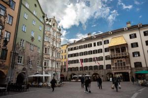 eine Gruppe von Menschen, die durch eine Stadtstraße gehen in der Unterkunft Apartments Golden Roof by Penz in Innsbruck
