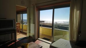 sala de estar con vistas a un balcón en Beach front sunset apartment, en Apúlia