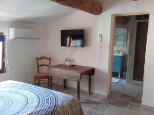 Dormitorio con escritorio, cama y TV en Appartement Domaine l'Oliveraie, en Le Castellet