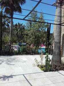 una valla negra con palmeras y una piscina en Appartement Domaine l'Oliveraie en Le Castellet
