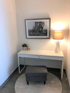 una scrivania bianca con lampada e sedia di Salinendomizil Bad Rothenfelde a Bad Rothenfelde