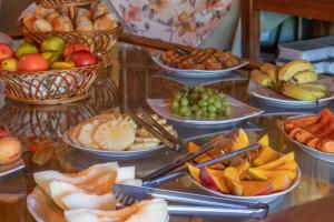 um buffet repleto de diferentes tipos de frutas e snacks em Bomtempo Itaipava by Castelo Itaipava em Itaipava