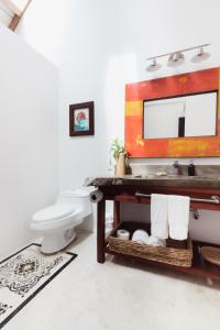 ein Badezimmer mit einem Waschbecken, einem WC und einem Spiegel in der Unterkunft Villas Los Olivos in Ayampe