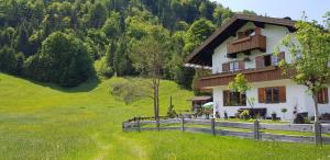 una casa en un campo verde con una valla en Am alten Skihang, en Wallgau