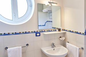 a bathroom with a sink and a mirror at Corte Di Nettuno - CDSHotels in Otranto