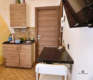 CORSINI HOUSES- CATANIA في كاتانيا: مطبخ صغير مع كونتر أسود وباب