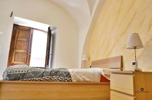 CORSINI HOUSES- CATANIA في كاتانيا: غرفة نوم بسرير ونافذة