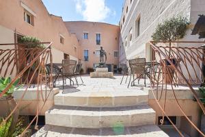 um pátio com uma fonte e cadeiras e uma estátua em Corte Di Nettuno - CDSHotels em Otranto