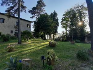 een tuin met een huis en wat bomen en gras bij Ca'Lavalle B&B in Urbino