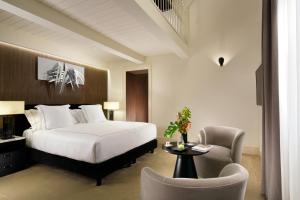 a hotel room with a bed and a chair at The First Dolce - Preferred Hotels & Resorts in Rome