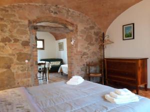 a bedroom with a bed and a stone wall at Podere Alberello in Torrita di Siena