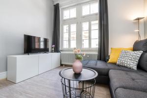 a living room with a couch and a tv at Freiburg Appartements am Augustinerplatz in Freiburg im Breisgau