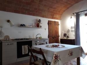 a kitchen with a table, chairs and a refrigerator at Podere Alberello in Torrita di Siena