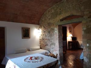 um quarto com uma cama e uma parede de pedra em Podere Alberello em Torrita di Siena