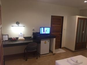 een kamer met een bureau, een televisie en een stoel bij Mamaungpaa Hill resort in Ta Khli