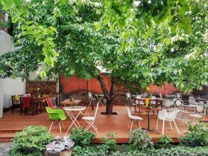 a patio with tables and chairs under a tree at Casa Miron 1 in Timişoara