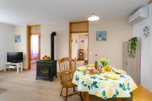 a dining room with a table and a stove at Vacation Home Daniela in Žgaljić