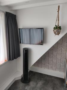 Habitación con espejo en la pared y ventilador. en Hoogland aan Zee en Egmond aan Zee