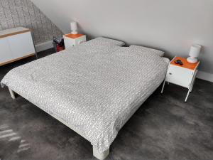 um quarto com uma cama e duas mesas de cabeceira em Hoogland aan Zee em Egmond aan Zee