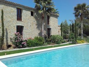 une maison avec une piscine en face d'un bâtiment dans l'établissement Appartement Domaine l'Oliveraie, au Castellet
