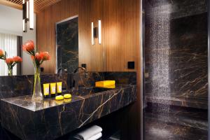 a bathroom with a black marble counter and a sink at The First Dolce - Preferred Hotels & Resorts in Rome +31 photos