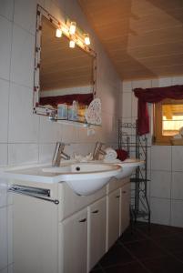 a bathroom with a white sink and a mirror at Haus Gaby in Holzgau