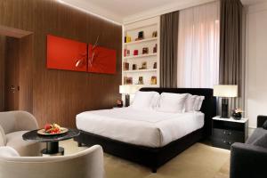 a hotel room with a bed and a table and chairs at The First Dolce - Preferred Hotels & Resorts in Rome