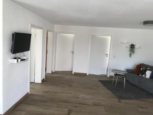 a living room with white walls and a tv at Ferienwohnung Scholter in Eichstegen