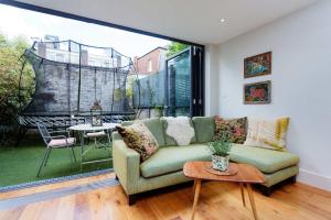 a living room with a couch and a large window at Veeve - Heaven in Highgate in London