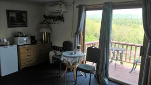 a kitchen with a balcony with a table and a tableablish at Midway Lodging in Cornish