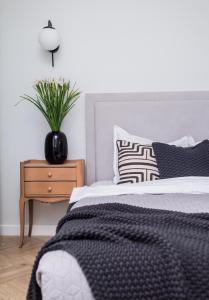 a bedroom with a bed and a table with a plant at Explore the City from Its Center in a Chic Balcony Apartment in Bucharest