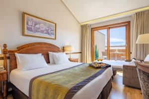 um quarto de hotel com uma cama grande e uma janela em Hotel Exe Reina Isabel em Ávila