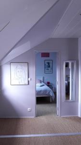 Zimmer mit einem Schlafzimmer mit einem Bett und einem Spiegel in der Unterkunft L'ecrin vannetais in Vannes
