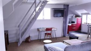 ein Wohnzimmer mit einer Treppe, einem Tisch und einer Küche in der Unterkunft L'ecrin vannetais in Vannes
