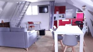 ein Wohnzimmer mit einem Sofa, einem Tisch und einer Treppe in der Unterkunft L'ecrin vannetais in Vannes