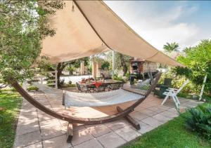 a hammock on a patio with a table and chairs at Villa Rosa Lifestyle B&B in Sessa Aurunca