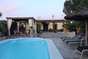 a swimming pool in a yard with chairs and a house at Llano San Ignacio in El Bosque