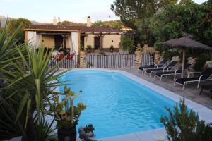a swimming pool with chairs and a house in the background at Llano San Ignacio in El Bosque +25 photos